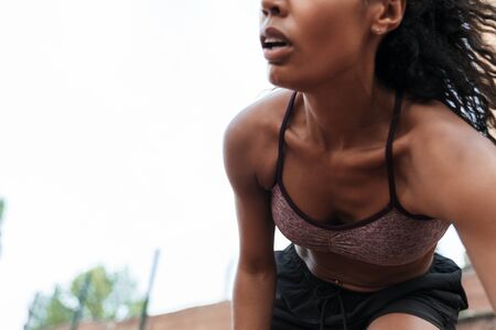 Image of fitness african american woman in sportswear doing workout at playground outdoorsの写真素材