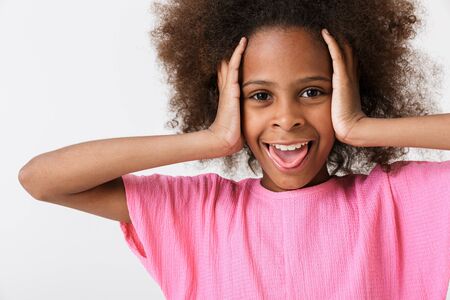 Cheerful funny little african girl wearing pink blouse standing isolated over white background,...