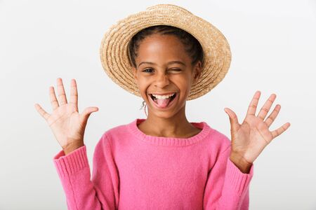 Image of smiling african american girl in straw hat grimacing and showing her palms isolated over...