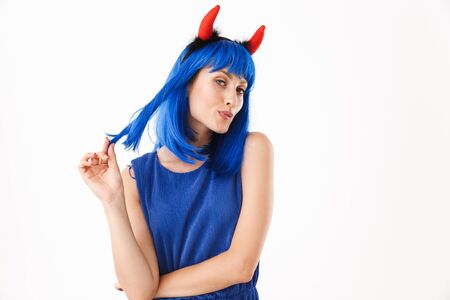Portrait of seductive woman wearing blue wig and toy devil horns dreaming while looking at camera...