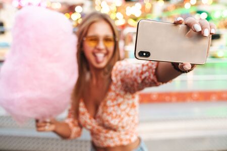 Photo of amazing pretty cute woman walking outdoors in amusement park eat candyfloss take selfie by...