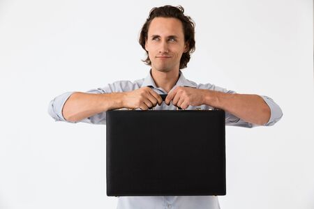 Image closeup of successful businessman in office shirt smiling and holding black briefcase isolated...
