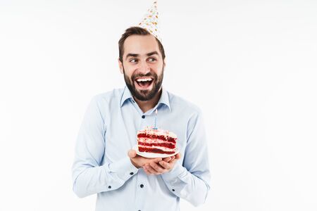 Image of masculine party man smiling and holding birthday cake with candle isolated over white backgroundの写真素材