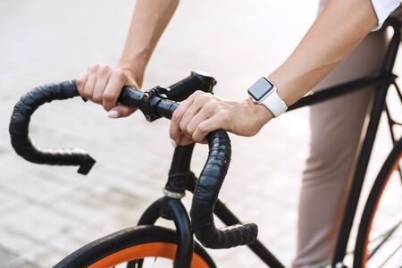Close uo of a young woman wearing summer clothes riding on a bicycle on a city streetの写真素材