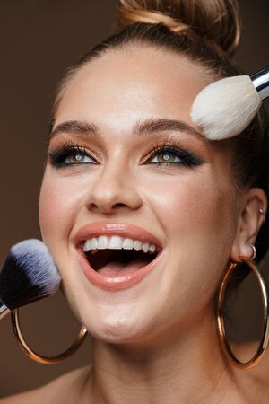 Close up beauty portrait of an attractive smiling young topless woman wearing accessories isolated...