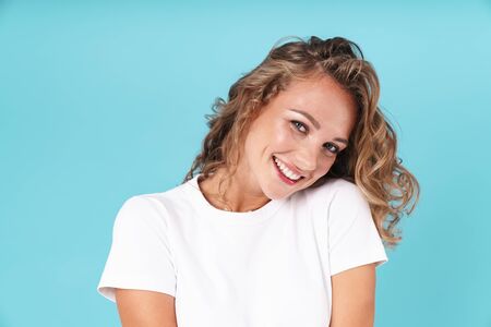 Attractive excited young girl wearing casual clothing standing isolated over blue background,...