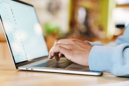 Close up of a businessman working on laptop computer indoors