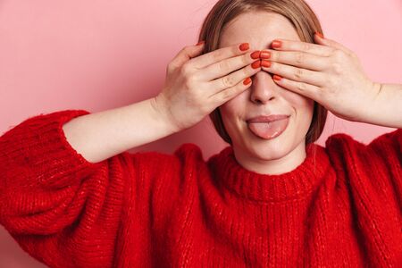 Image of optimistic happy young cute woman posing isolated over pink wall background covering eyes...