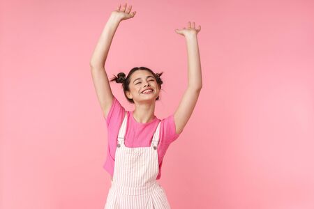 Photo of lovely charming girl with nose ring dancing and smiling at camera isolated over pink backgroundの写真素材