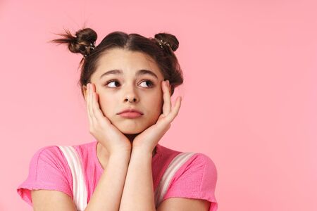 Photo of sad charming girl with nose ring posing at camera and looking aside isolated over pink backgroundの写真素材