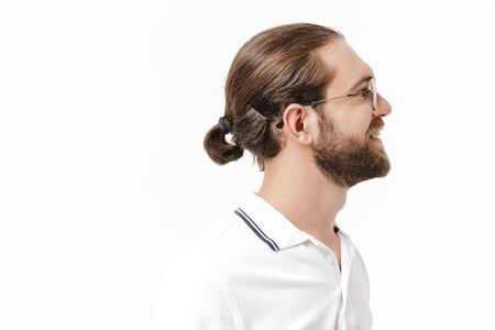 Side view of an attractive young bearded man wearing casual outfit standing isolated over white backgroundの写真素材