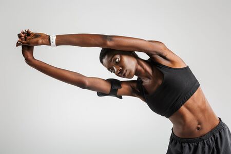 Image of african american sportswoman doing exercise while working out isolated over white...