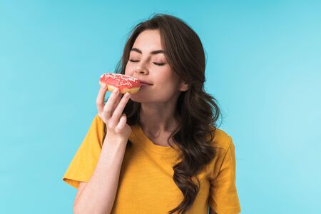 Image of pleased optimistic positive young pretty woman posing isolated over blue wall background...