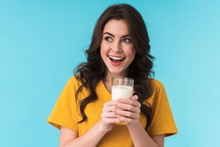 Image of happy positive optimistic young beautiful woman posing isolated over blue wall background...