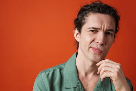 Image of confused caucasian man posing and looking at camera isolated over orange backgroundの写真素材