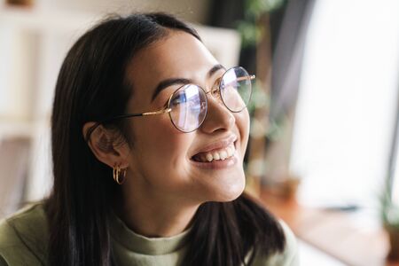 Image of a beautiful cheerful optimistic young girl student indoors.