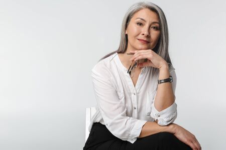 Image of adult mature woman with long gray hair wearing office clothes isolated over white backgroundの写真素材