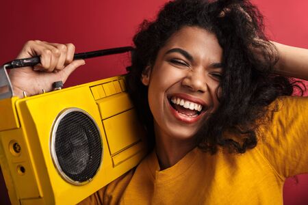 Image of beautiful brunette african american woman with curly hair laughing and holding vintage...