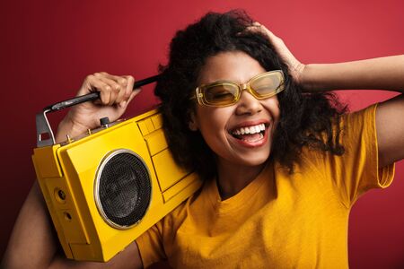 Image of beautiful brunette african american woman with curly hair laughing and holding vintage...