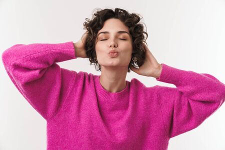 Image of happy caucasian woman making kiss lips and grabbing her head isolated over white backgroundの写真素材