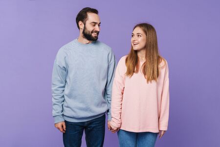 Picture of happy positive loving couple isolated over purple background.の写真素材