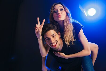 Image of a happy young amazing loving couple having fun resting in a night disco club on concert...