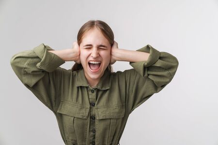 Photo of annoyed young woman screaming and grabbing her head isolated over white background
