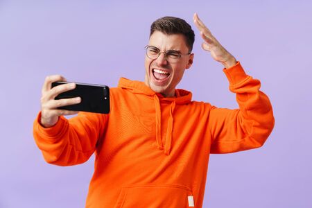 A positive happy young man take a selfie by mobile phone.