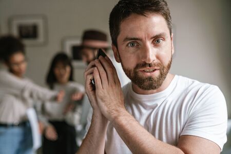 Multiethnic young business people working together at office. Man using cellphoneの写真素材