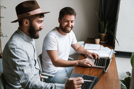 Caucasian young male colleagues discussing business ideas while working in office