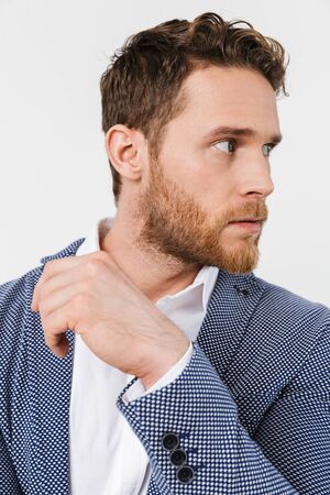 Image of confident young man wearing jacket posing and looking aside isolated over white background