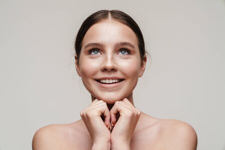 Image of joyful nice shirtless woman smiling and looking upward isolated over grey backgroundの写真素材