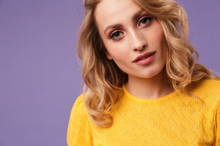 Image of nice serious woman posing and looking at camera isolated over purple backgroundの写真素材