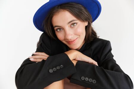 Image of a beautiful cheerful optimistic happy woman in blue hat posing isolated over white wall background.の写真素材