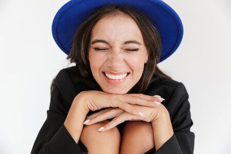 Image of a beautiful cheery happy woman in blue hat posing isolated over white wall background.の写真素材