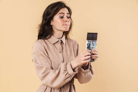 Image of surprised woman taking selfie photo with birthday cake isolated over beige background