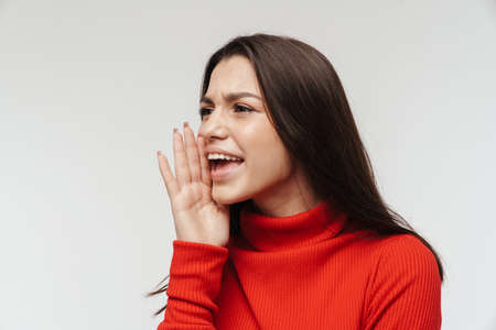 Photo of displeased beautiful woman looking and screaming aside isolated over white wall