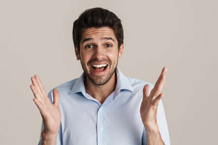 Portrait of excited handsome man expressing surprise on camera isolated over white background
