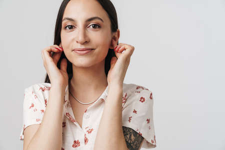 Photo of joyful beautiful woman plugging his ears and smiling isolated over white background
