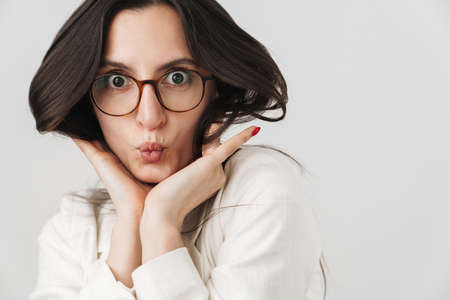 Photo of amusing businesswoman making fun and grimacing on camera isolated over white background