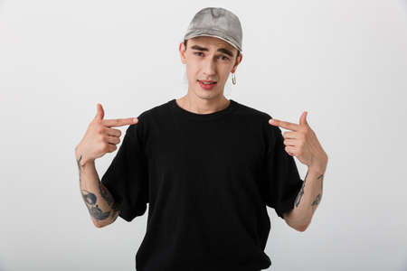 Portrait closeup of handsome confused man wearing black clothes looking at camera and pointing...