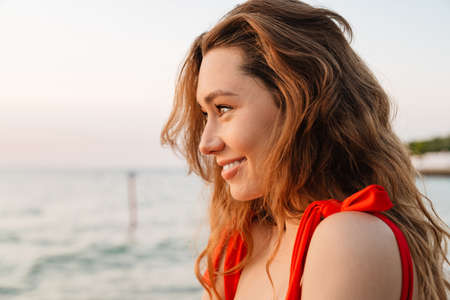 Beautiful smiling young woman wearing bikini at the beach, close up