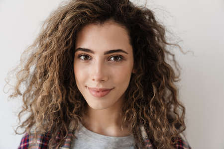 Photo of happy beautiful woman smiling while posing on camera isolated over white backgroundの写真素材
