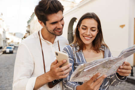 Couple of travelers with map of town deciding where to go