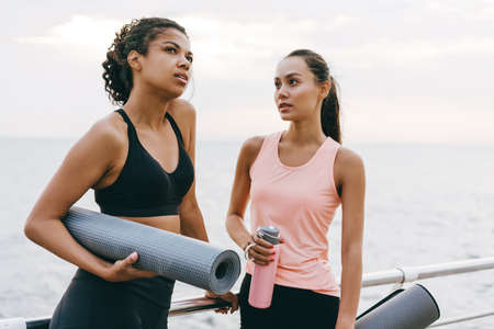Image of thinking multinational sportswomen talking after workout on promenadeの写真素材