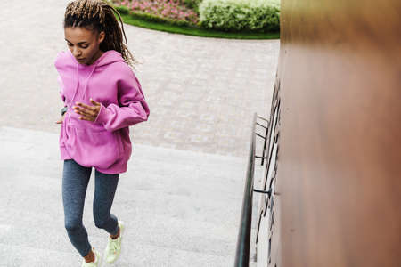 Top view of a fit young sportswoman exercising on stairs outdoors, running