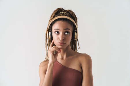 Portrait of beautiful pensive african brunette woman with dreadlocks a listening music via wireless...