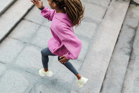 Top view of a fit young sportswoman exercising on stairs outdoors, runningの写真素材