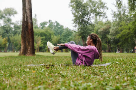 Beautiful younf african sport girl doing yoga exercises in the park