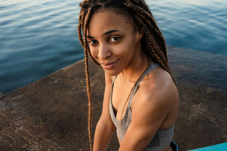 African woman practicing yoga at the beach. Close up
